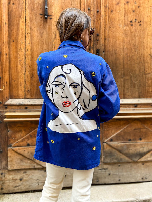 Veste bleu de travail customisée d'un visage abstrait style Castelbajac