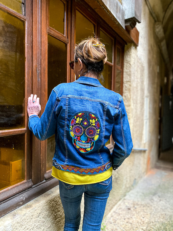 Veste en jean customisée d'une tête de mort en sequins multicolores