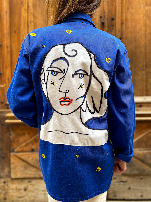 Veste bleu de travail customisée d'un visage abstrait style Castelbajac