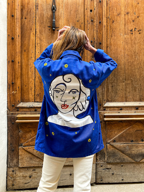 Veste bleu de travail customisée d'un visage abstrait style Castelbajac